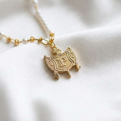 Macro shot of a fine gold chain necklace resting on white silk, highlighting micro-texture and subtle shine under natural light.