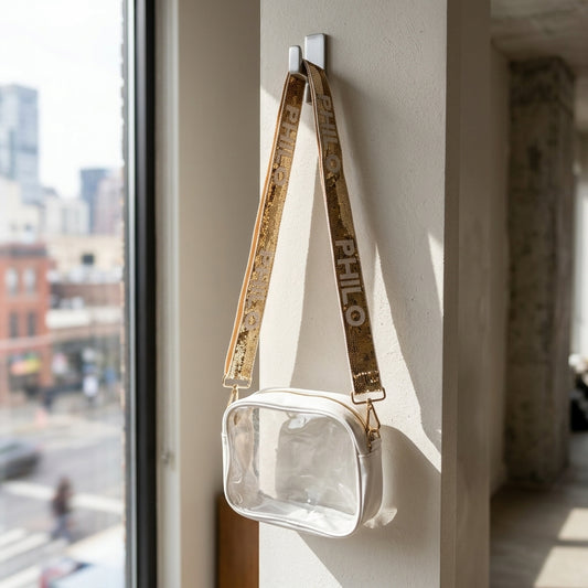 Full-body view of the PHILO Crossbody Concert Bag hanging from a modern hook in an urban setting with cityscape background.